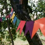 Brightly colored streamers hanging on a tree, creating a festive outdoor atmosphere.